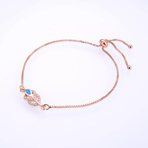 Detail of rose gold leaf bracelet with opal stone and micro-paved zircons on white backdrop
