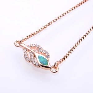 Macro detail of rose gold leaf bracelet with iridescent blue opal and cubic zirconia