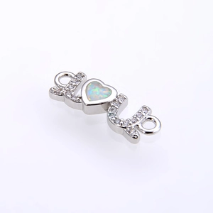 Detailed close-up of opal heart LOVE connector with micro-pave cubic zirconia settings