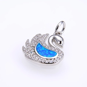 Detailed close-up of swan pendant with blue opal stone and micro-pave crystals
