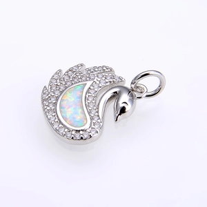 Macro shot of silver swan pendant featuring white fire opal and sparkling zircon crystals