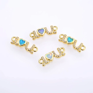 Close-up of gold LOVE connectors with opal hearts and zircons for DIY jewelry making