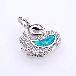 Macro detail of swan pendant with blue opal gemstone and micro-pave white zircons