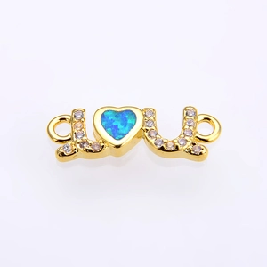 Macro shot of gold LOVE opal heart connector with white zircons for jewelry making