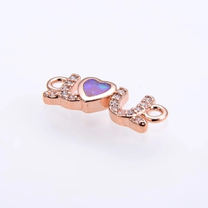 Macro detail of rose gold LOVE connector with heart opal and sparkling crystals