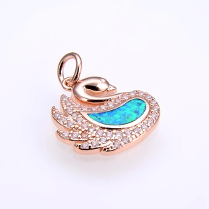 Detail of rose gold swan pendant featuring a vibrant blue opal and pavé crystals