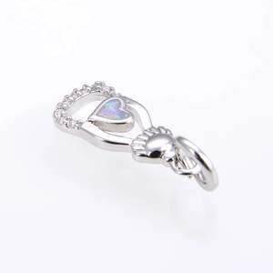 Dettaglio macro del ciondolo a cuore Claddagh con opale e pavé di zirconi