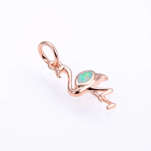 Macro shot of rose gold flamingo pendant featuring a vibrant blue-green opal gemstone