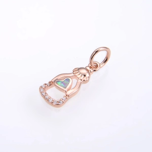 Dettaglio macro del ciondolo cuore in opale oro rosa con accenti in zirconia su sfondo bianco