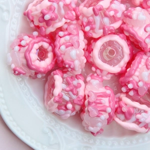 Gros plan détaillé de perles en verre floral rose pour la fabrication de bijoux DIY