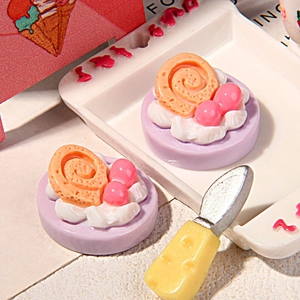 Nahaufnahme von Miniatur-Resin-Kuchen in Lila mit Sahnehäubchen auf einem weißen Tablett