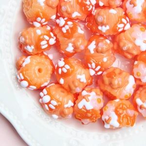 Vue détaillée de perles orange avec empreintes de pattes pour la création de bijoux DIY
