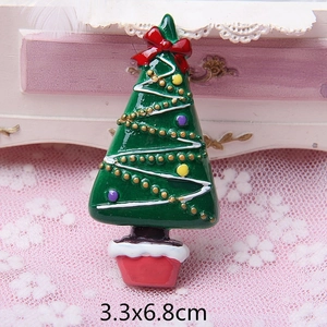 Detail view of a 3.3x6.8cm green enamel Christmas tree brooch with festive decorations