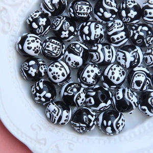 Macro shot of assorted black and white acrylic beads with cute cat and flower patterns