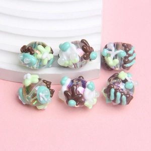 Macro detail of six acrylic hand-painted beads with 3D floral patterns for DIY jewelry