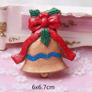 Detail of Christmas bell magnet with gold glitter, red bow, and festive holly leaves