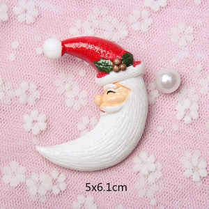 Macro shot of 5x6.1cm Christmas moon brooch with Santa face and glitter finish