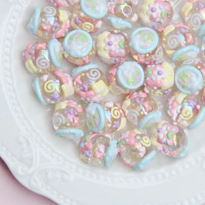 Macro detail of macaron colored acrylic beads with embossed patterns and pearl finish