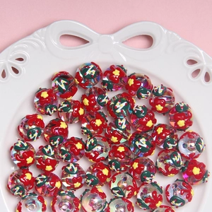 Macro shot of colorful Christmas style beads with floral patterns on a white ceramic plate