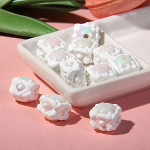 Vue macro de perles en résine blanche avec motifs floraux en relief et centres irisés