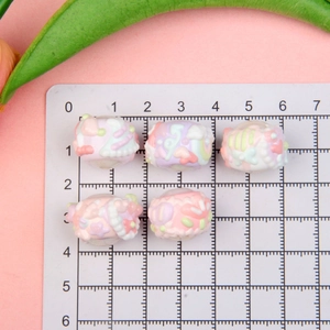 Macro view of macaron resin beads with floral relief and large hole for DIY jewelry