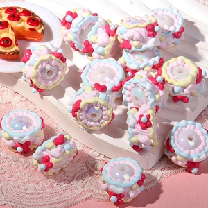 Macro detail of hand-painted acrylic cake charms for DIY jewelry making and phone chains