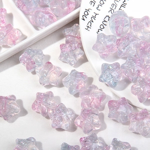 Detalle macro de cuentas en forma de estrella con acabado aurora y purpurina para joyas
