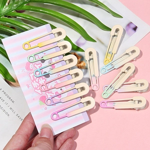 Detail of sweet gradient macaron safety pin hair clips set on aesthetic magazine background