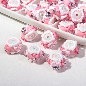 Makro-Detail von rosa DIY-Blumenperlen mit herzförmigen Strasssteinen auf Stoff