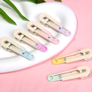 Matte gradient duckbill hair clips set in 6 colors on a heart ceramic plate