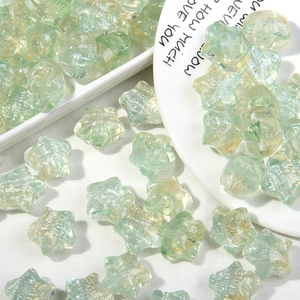 Vista macro de cuentas de vidrio estrella verde claro con purpurina para hacer joyería DIY