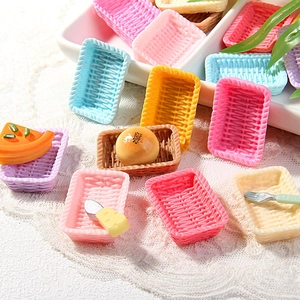 Miniature colorful woven baskets with toy food and tableware on a lace tablecloth