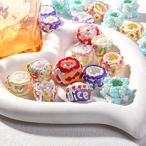 Detailed view of DIY resin beads in creamy cake shapes with floral and heart patterns