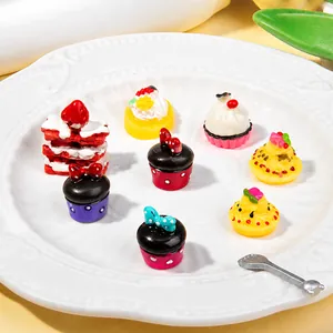 Eight miniature resin cupcakes and dessert models displayed on a white ceramic plate