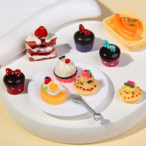 Macro shot of assorted resin cupcake miniatures and miniature dessert charms for dollhouse DIY