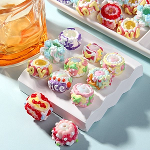 Close-up of colorful DIY resin beads with embossed heart and strawberry patterns