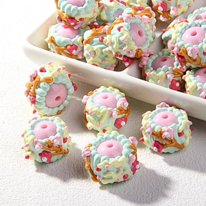Detail view of handmade oil-painted resin beads with embossed floral patterns for DIY jewelry