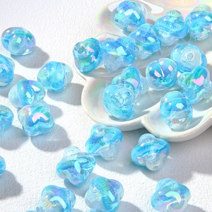 Macro-opname van blauwe laserglans bloemkralen voor DIY-sieraden op een wit porseleinen bord