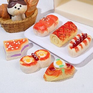 Macro shot of assorted miniature resin pastry models including cakes and sandwiches