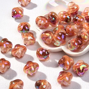 Macro-opname van amberkleurige iriserende glazen bloemkralen voor DIY-sieraden maken