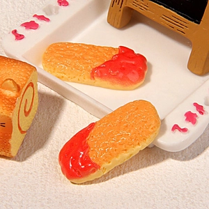 Close-up of miniature resin ladyfinger biscuits with red jam detail for DIY crafts