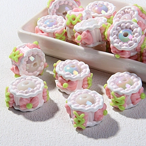 Detail of DIY cake-shaped beads with pink bows and iridescent pearls for jewelry making