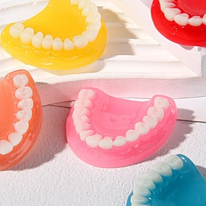 Colorful realistic 3D tooth resin charms in multiple shades on white display stand