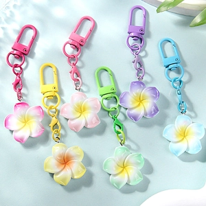 Colorful plumeria flower keychains with matte metal clips in six vibrant gradient shades