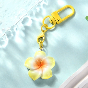 Detailed close-up of a gradient yellow resin frangipani keychain with matching color metal hook