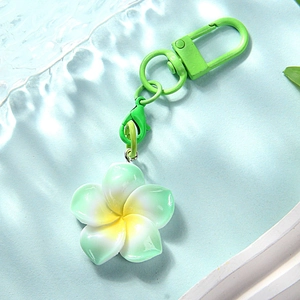 Detail of fresh green plumeria keychain with matching lacquer hardware on wavy tray