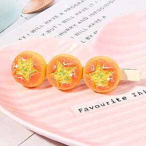 Macro detail of cute orange star clips on a pink heart tray with warm aesthetic vibes