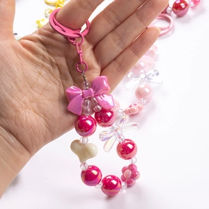Macro view of a colorful handmade beaded phone strap with pink bows and floral beads