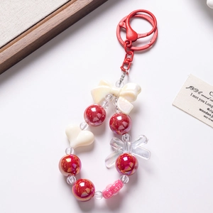 Close-up of beaded phone chain with red bows, white hearts and a metal lobster clasp