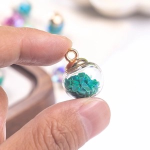Clear glass ball pendant with green heart sequins and golden loop for DIY jewelry
